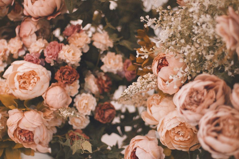 A stunning collection of pink roses and peonies with delicate foliage, perfect for spring floral arrangements.